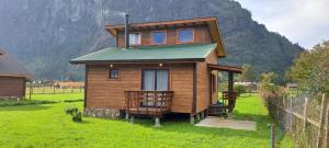 a tiny house in a field with a mountain in the background at Cabañas Llifén Costanera in llifen