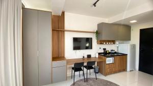 a kitchen with a table and chairs and a refrigerator at Apartamento com Piscina no Rooftop in São Paulo