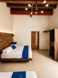 a bedroom with a large bed and a wooden headboard at Hotel Queretaro in Querétaro +26 photos