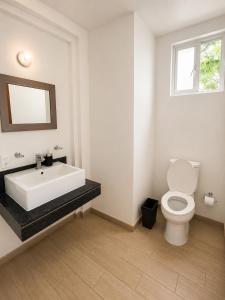 a bathroom with a tub and a toilet and a window at Hotel Queretaro in Querétaro