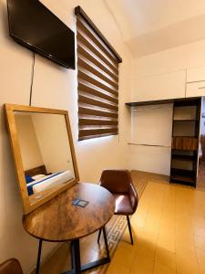 a room with a mirror and a table and a chair at Hotel Queretaro in Querétaro
