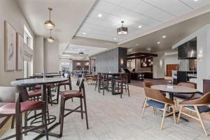 a restaurant with tables and chairs in a cafeteria at Drury Plaza Hotel Mobile in Mobile
