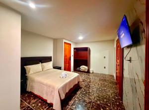 a bedroom with a bed and a flat screen tv at El encanto de Zacatlan in Zacatlán