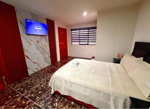 a bedroom with a bed and a tv on the wall at El encanto de Zacatlan in Zacatlán