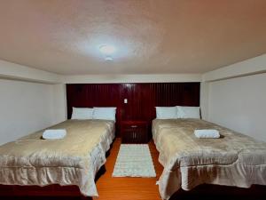 two beds in a hotel room with two bedsskirts at El encanto de Zacatlan in Zacatlán