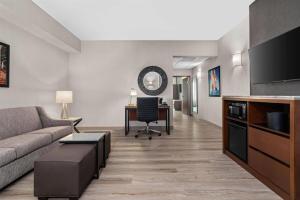 a living room with a couch and a desk at Drury Plaza Hotel Mobile in Mobile