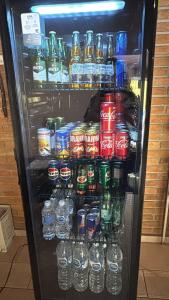 a refrigerator filled with lots of cans and bottles of soda at Pousada Hostel Brazil Backpackers in Guarujá