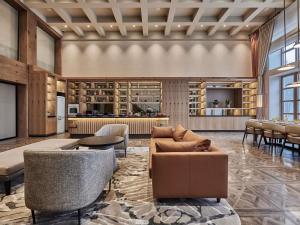 a lobby with couches and tables and a kitchen at Swissotel Uludag Bursa in Bursa