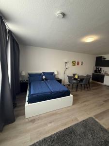a bedroom with a bed with blue sheets and a table at Modern Apartment Close to Bus Station in Würzburg