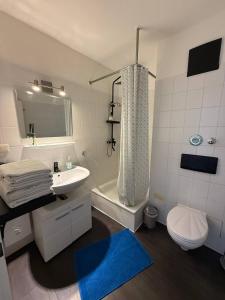 a bathroom with a sink and a tub and a toilet at Modern Apartment Close to Bus Station in Würzburg