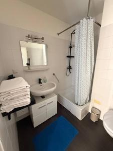 a bathroom with a sink and a toilet and a tub at Modern Apartment Close to Bus Station in Würzburg