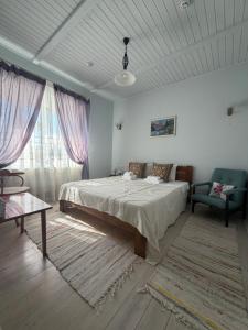 a bedroom with a bed and a couch and a window at Pensiunea Casa Veche in Palanca