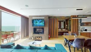 a living room with a blue couch and a table at Bliss Properties Jacuzzi Suite Free Pool Access in Draç
