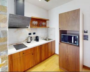 a kitchen with a sink and a microwave at Bliss Properties Jacuzzi Suite Free Pool Access in Draç