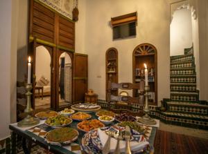 a table with many plates of food on it at Dar Ras Jnan -luxury stay - rooftop in Oulad Akkou