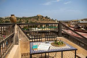 a table on top of a balcony with a book at Dar Ras Jnan -luxury stay - rooftop in Oulad Akkou