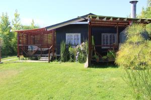 a house with a pergola in a yard at Cabañas Alfa Colbun Machicura in Linares