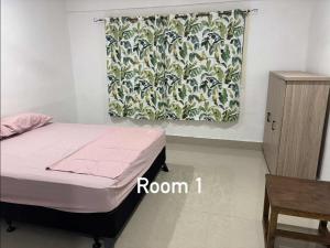 a bedroom with a bed and a curtain and a table at NiNo in Vaitele