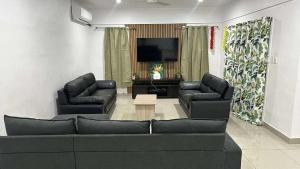a living room with two couches and a flat screen tv at NiNo in Vaitele