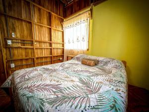 a bedroom with a bed with a leaf patterned blanket at Casa Chilamate in Puerto Jiménez