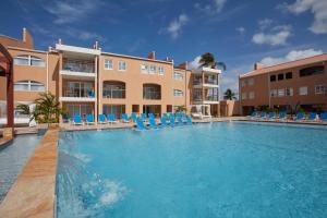 a large swimming pool with chairs and a hotel at Divi Dutch Village Beach Resort in Palm-Eagle Beach