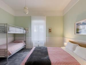 a bedroom with two bunk beds and a bed with a blanket at The Fenway Hostel in Launceston