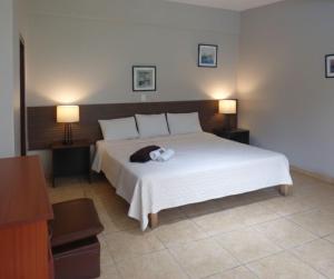 a bedroom with a bed with a cat laying on it at El Angolo Chosica in Nicolas de Pierola +3 photos