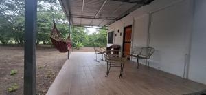 a porch with a table and an umbrella and chairs at House of Dreams in Nicoya