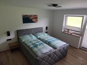 a bedroom with a bed and a window at PS-Apartment Luis in Vorderthiersee