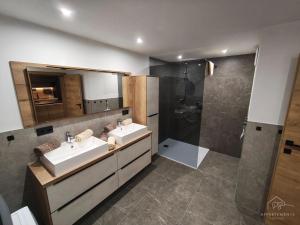 a bathroom with two sinks and a shower at PS-Apartment Luis in Vorderthiersee +20 photos