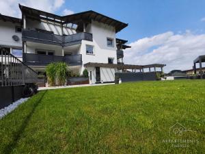 a house with a green lawn in front of it at PS-Apartment Luis in Vorderthiersee
