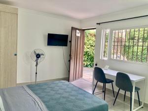 a bedroom with a bed and a desk and a window at Poblado-Aguacatala Apart-Hotel in Envigado