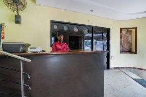 a man standing behind a bar in a restaurant at Hotel O Pariwar Inn in Hyderabad +25 photos