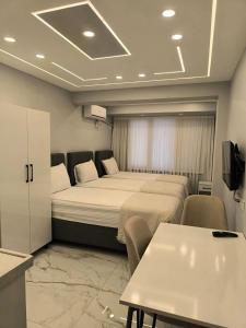 a hotel room with two beds and a table at Vizyon Konak in Burhaniye