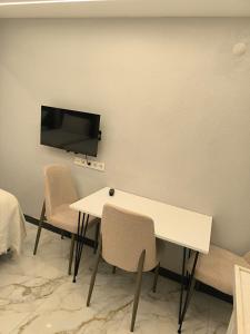a room with a table and chairs and a tv on the wall at Vizyon Konak in Burhaniye