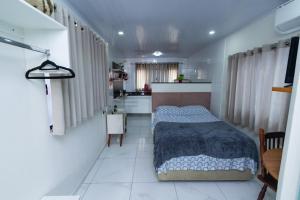 a small bedroom with a bed and a kitchen at Casa do Henrique 2 in Sorocaba