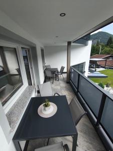a balcony with a black table and chairs at PS-Apartment Luis in Vorderthiersee