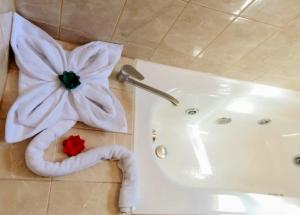 a bathroom with a flower on the floor next to a bath tub at Hotel Iorana Tolache in San Pedro de Atacama +36 photos
