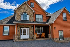 a log home with a front door and a patio at Luxury 6 BED 5 BATH Mountain Cabin HOT TUB Theater Sleeps 20 IDEAL LOCATION Fireplace KING SUITES Fire Pit GAME ROOM in Sevierville