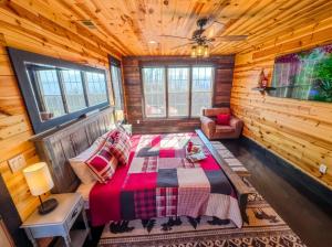 a bedroom with a bed in a log cabin at Luxury 6 BED 5 BATH Mountain Cabin HOT TUB Theater Sleeps 20 IDEAL LOCATION Fireplace KING SUITES Fire Pit GAME ROOM in Sevierville