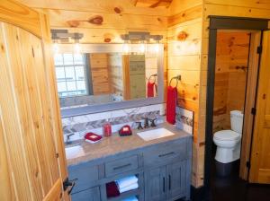 a bathroom with two sinks and a toilet at Luxury 6 BED 5 BATH Mountain Cabin HOT TUB Theater Sleeps 20 IDEAL LOCATION Fireplace KING SUITES Fire Pit GAME ROOM in Sevierville +44 photos