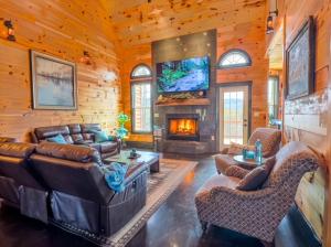 a living room with leather furniture and a fireplace at Luxury 6 BED 5 BATH Mountain Cabin HOT TUB Theater Sleeps 20 IDEAL LOCATION Fireplace KING SUITES Fire Pit GAME ROOM in Sevierville