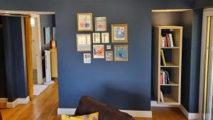 a room with a blue wall with pictures on it at A quiet gem just outside Oundle in Oundle +3 photos