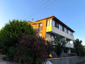 a yellow house with flowers in front of it at Vizyon Konak in Burhaniye