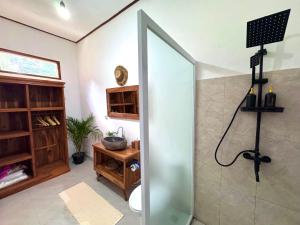 a bathroom with a shower with a glass door at AVYANA sanctuary in Gobleg