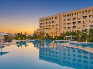 a hotel with a pool in front of a building at Mövenpick Hotel Waad Al Shamal in Ţurayf