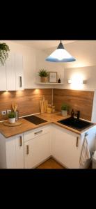 a kitchen with white cabinets and a sink and a light at L'Ephémère in Paroy-sur-Tholon