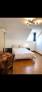 a bedroom with a bed and a table in it at L'Ephémère in Paroy-sur-Tholon