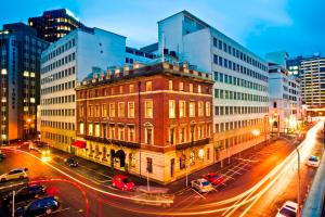 a building on a city street at night with traffic at Wellesley Boutique Hotel in Wellington