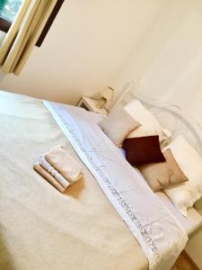 - un lit avec des draps et des oreillers blancs dans l'établissement Holiday Home Villa Monica, à Koreniki